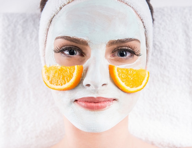 Woman holding orange slices and mask on the face. Premium Photo