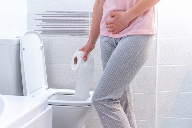 Premium Photo | Woman holding a paper roll and suffering from diarrhea ...