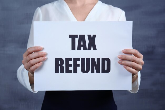 premium-photo-woman-holding-paper-sheet-with-text-tax-refund-on-color