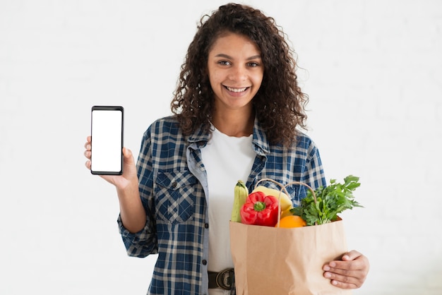 Download Woman holding a vegetables bag and a phone mock up | Free ...