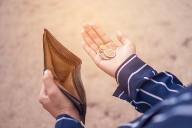 premium-photo-woman-holds-an-empty-purse-and-coins-in-hand-meaning