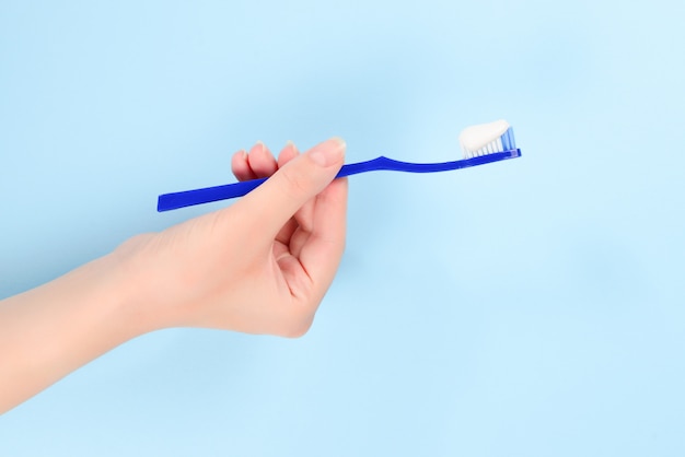 Premium Photo | Woman holds toothbrush with toothpaste in her hand on a ...