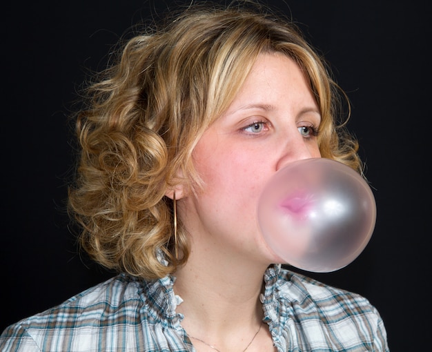 Premium Photo | Woman is doing bubble with bubble gum