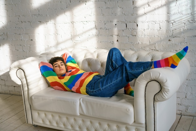 Premium Photo Woman Is Lying On A Sofa In A Multicolored Sweater And