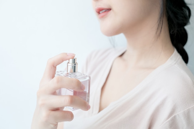 premium-photo-woman-is-spraying-perfume-at-the-neck
