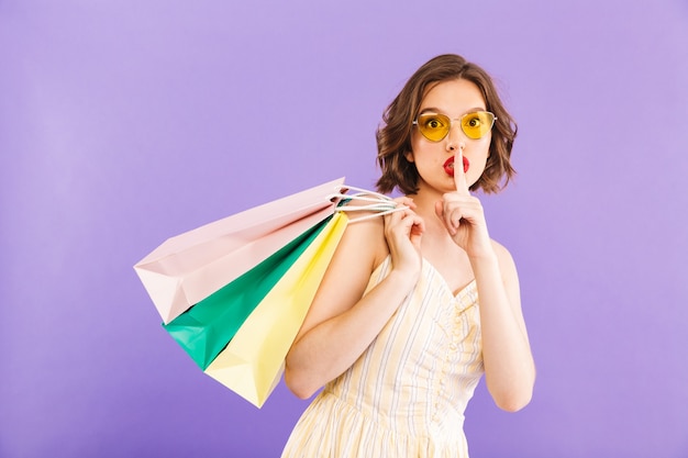 Premium Photo | Woman isolated holding shopping bags showing silence ...