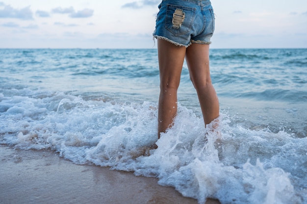 ビーチで水しぶき海の波と女性の足 プレミアム写真