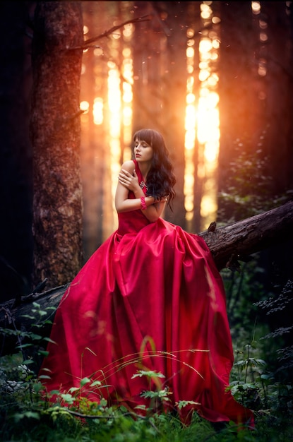 Premium Photo | Woman in a long red dress alone in the forest