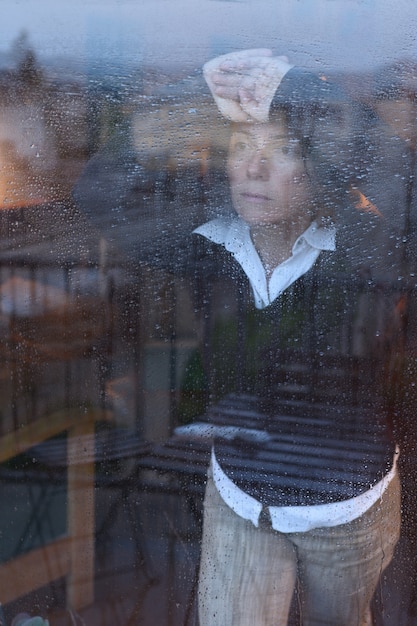 Premium Photo | Woman looking out the window on a rainy day