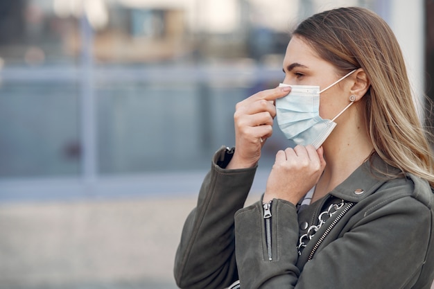 Woman in a mask stands on the street Free Photo