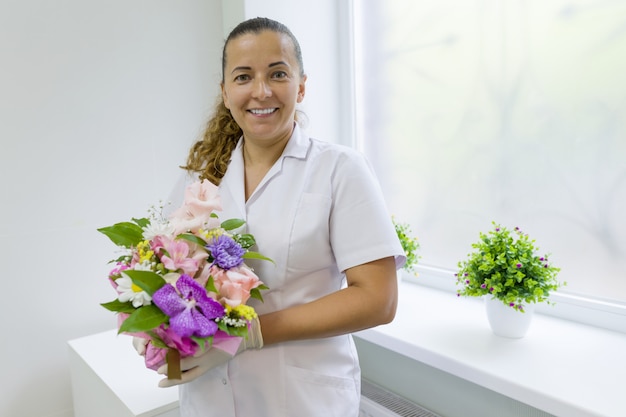 Woman nurse with bouquet of flowers | Premium Photo