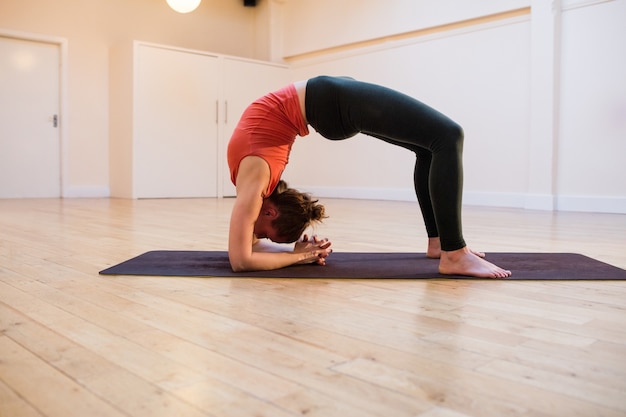 Free Photo | Woman performing chakrasana on exercise mat