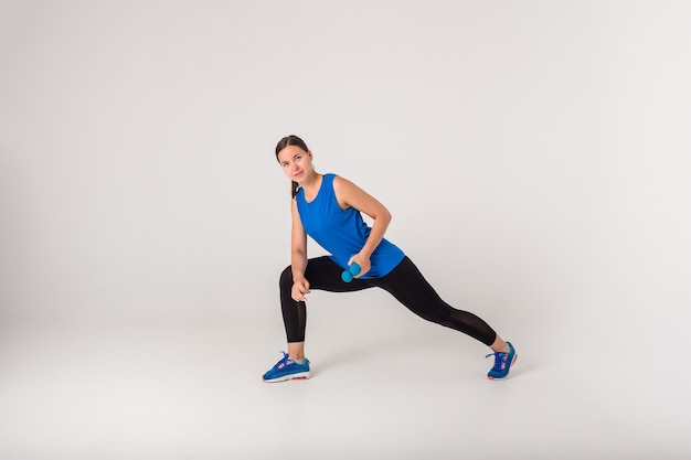 Premium Photo | A woman performs a lunge exercise with dumbbells and ...