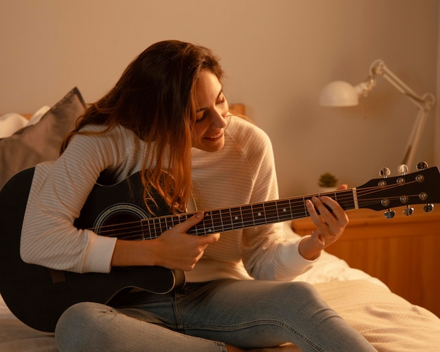 Free Photo Woman Playing Guitar At Home In Bed 1878