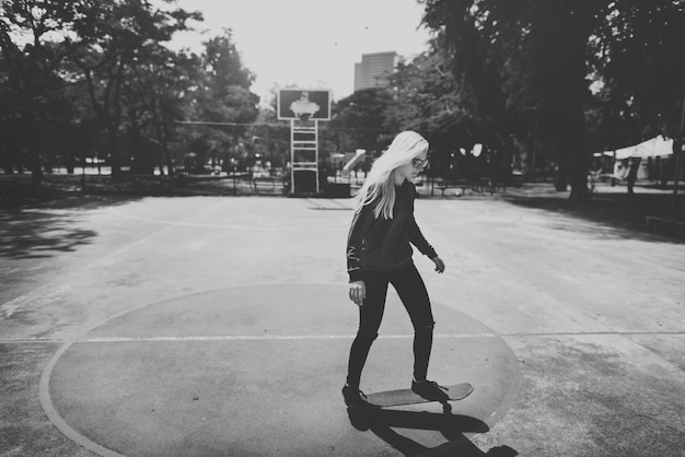 Free Photo | Woman playing skateboard in basketball court