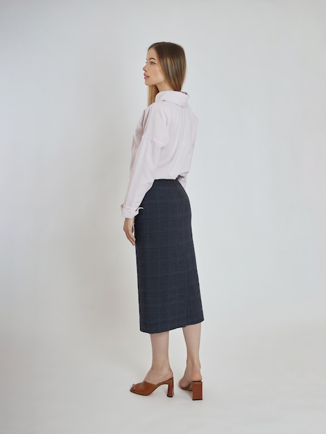 Premium Photo | Woman poses with blue skirt and white blouse