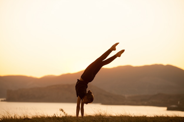 Premium Photo | Woman practices yoga in the mountains on the ocean.