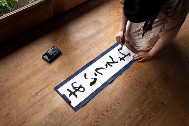 Free Photo | Woman Practicing Japanese Handwriting At Home