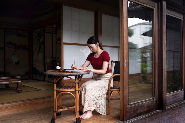 Free Photo | Woman practicing japanese handwriting indoors