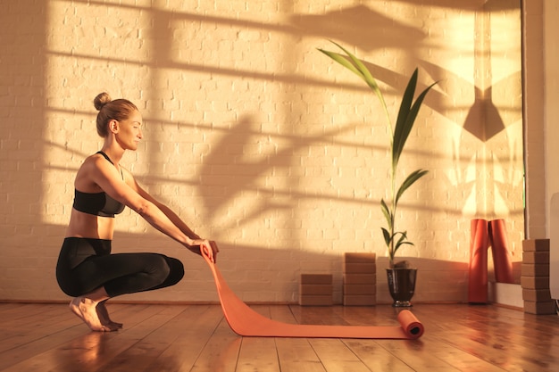 Woman Preparing For Doing Yoga Lying Down A Mat On The Floor