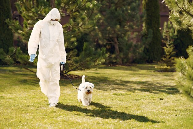 Free Photo | Woman in a protective suit walking with a dog