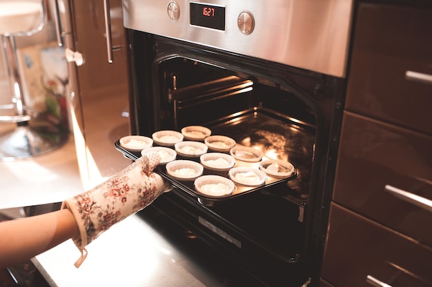 premium-photo-woman-put-batter-for-cupcakes-in-oven