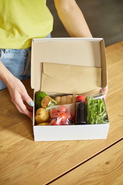 Premium Photo | Woman put on the table food box meal kit of fresh ...