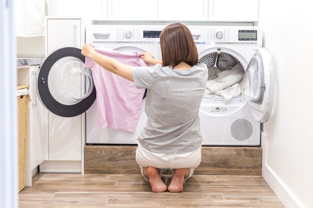 premium-photo-woman-putting-clothes-to-washing-machine-for-wash