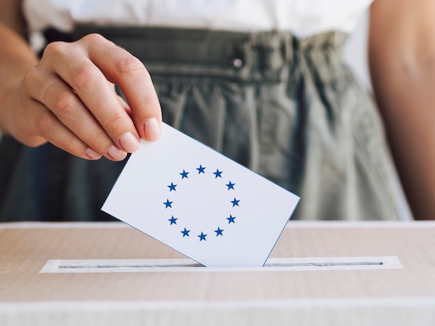 Woman putting her ballot in a box Free Photo