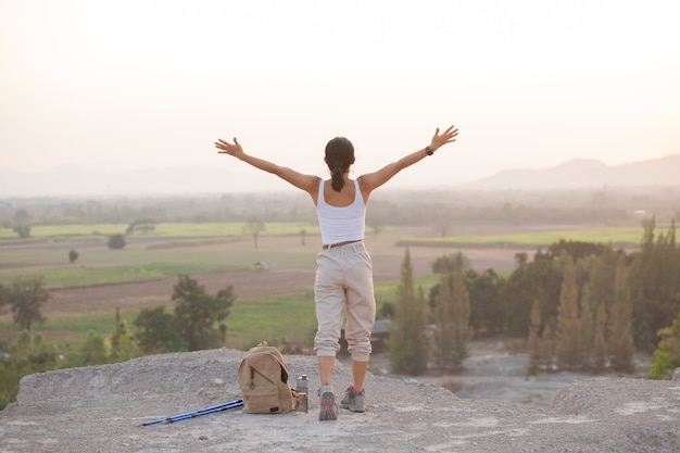 Free Photo | Woman raising hands up on the top of a mountain while ...