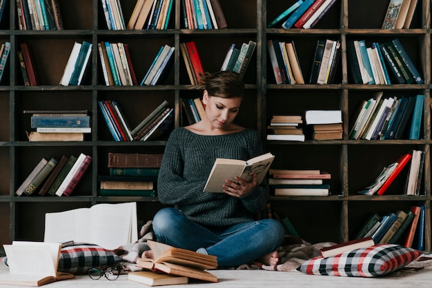 Free Photo | Woman reading books near old bookcase