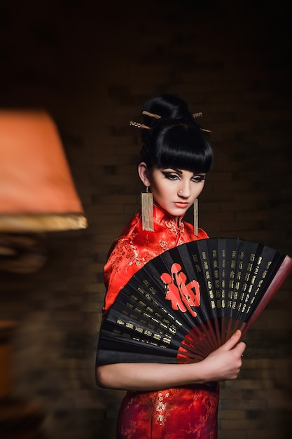 Premium Photo | Woman in a red japanese silk dress qipao in a dark ...