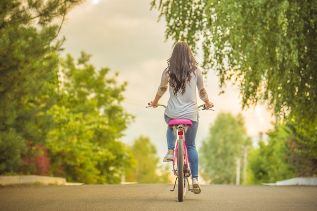 Premium Photo | The woman riding a bike on a road