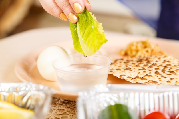 Premium Photo A Womans Hand At The Easter Seder Table Dips Maror And Karpas In Salt Water 9616