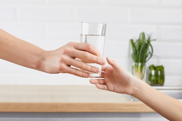 Woman's hand gives a glass of purified water to her child. concept purification of water Premium Photo