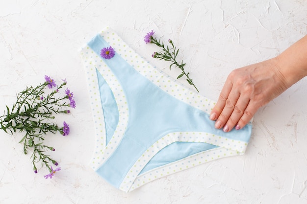 Premium Photo | Woman's hand holding beautiful blue cotton panties with ...