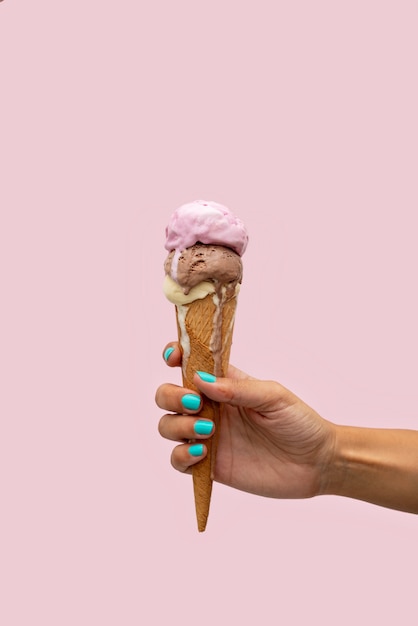 Premium Photo Womans Hand Holding An Ice Cream Cone Melting In A Pink