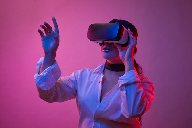 Premium Photo | Woman's playing in vr-glasses in neon light on blue ...