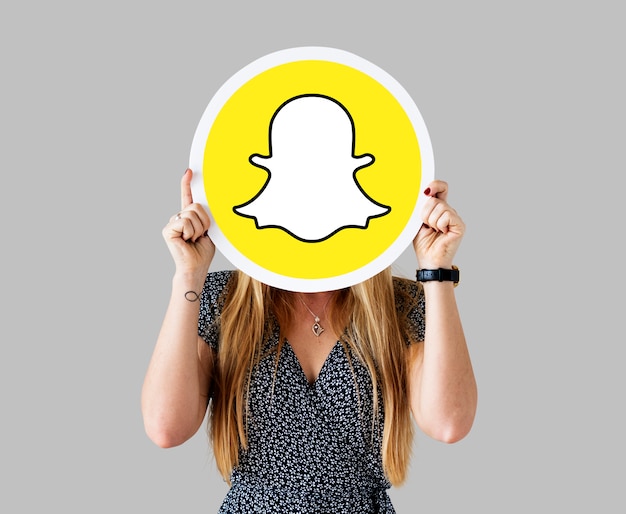 Woman showing a snapchat icon Free Photo