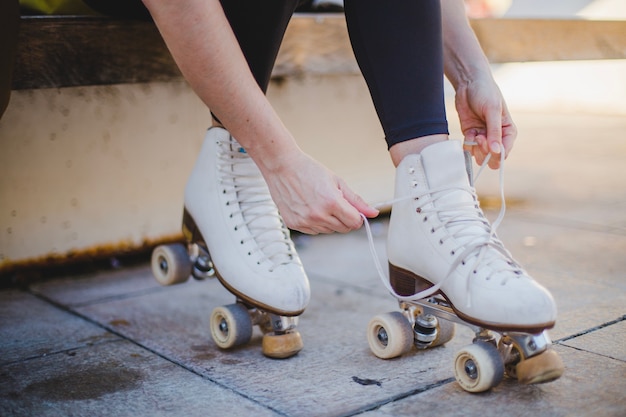 Woman sitting lacing roller skates Photo | Free Download