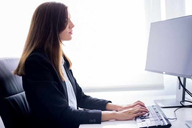 Free Photo | Woman sitting typing on a computer