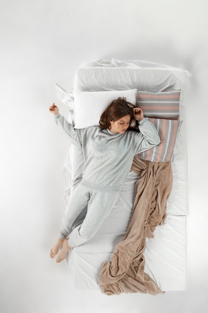 夢を見ながら一人で寝てベッドで休む女性 上からの平面図 無料の写真