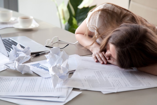 Woman Sleeping On Desk Covered Crumpled Papers Free Photo