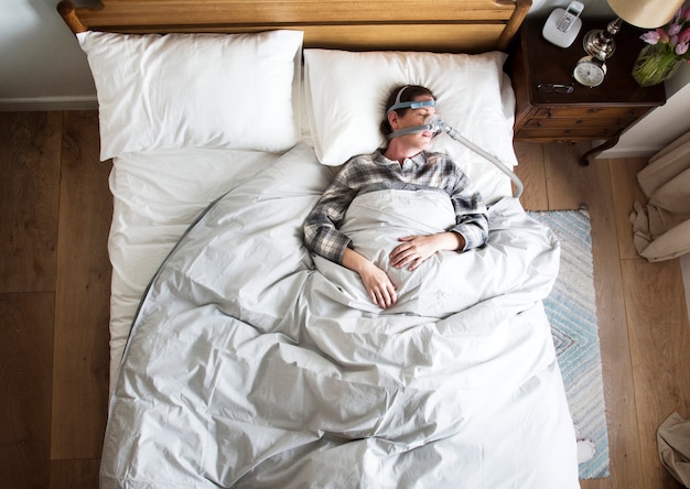 Woman sleeping with an anti-snoring mask Premium Photo