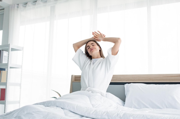 Premium Photo | Woman stretching after waking up in the morning ...