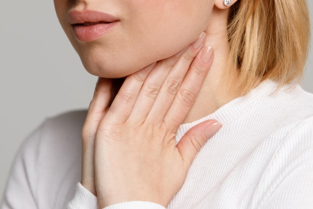 Woman suffering from throat problems, holding hands on her lymph nodes Premium Photo