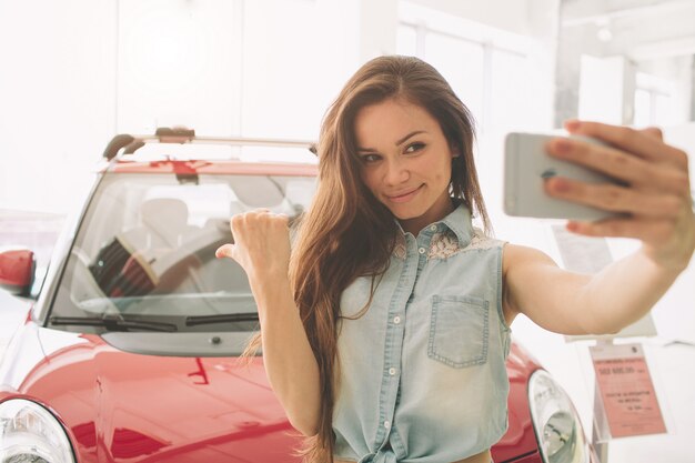 Premium Photo | Woman take selfie in a new car at showroom.