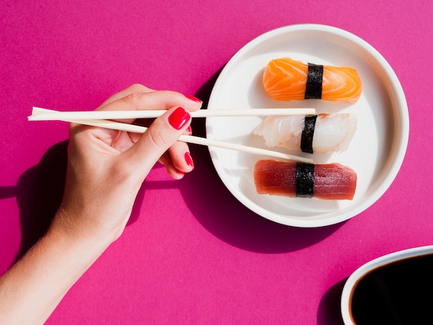 Free Photo | Woman taking a sushi piece with chopsticks