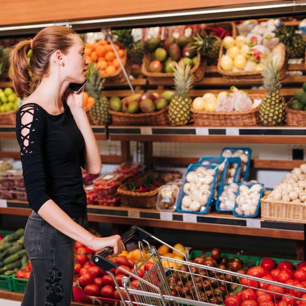 Free Photo | Woman talking on the phone at the grocery store