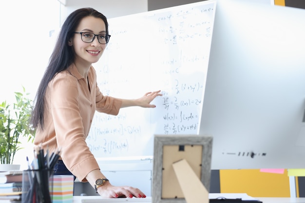 Premium Photo | Woman teacher showing math formulas in ...